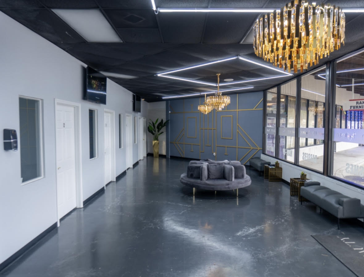 Everything Beauty Salon Suites lounge with gold chandeliers and suite doors